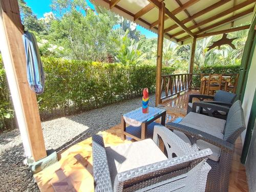 a patio with chairs and tables on a porch at New Caribe Point in Cahuita
