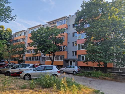 a parking lot with cars parked in front of an apartment building at Apart Harmony in Ruse