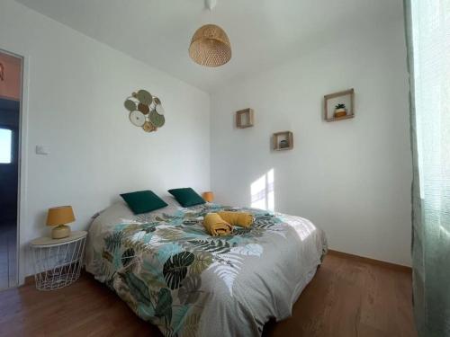 - une chambre avec un lit et des oreillers verts dans l'établissement Logement en Périgord, à Marquay