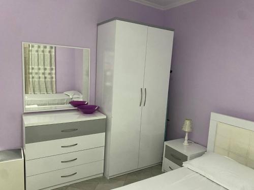 ポグラデツにあるGenti Guesthouseの白いキャビネットと鏡付きのベッドルーム1室