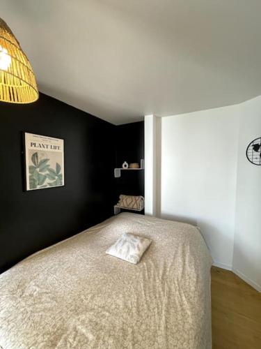 - une chambre avec un lit et un mur noir dans l'établissement Modern Art Vierzon Centre ville, à Vierzon