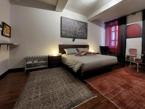 a bedroom with a bed and a table and a window at Le Cœur Urban Suite Parma in Parma