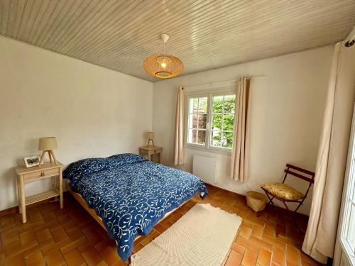 une chambre avec un lit bleu et une fenêtre dans l'établissement Maison calme entre plage et centre, à Noirmoutier-en-l'lle