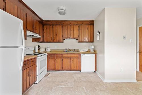a kitchen with wooden cabinets and white appliances at Prime Location 2 BR Oasis with Washer and Dryer in Spring Grove