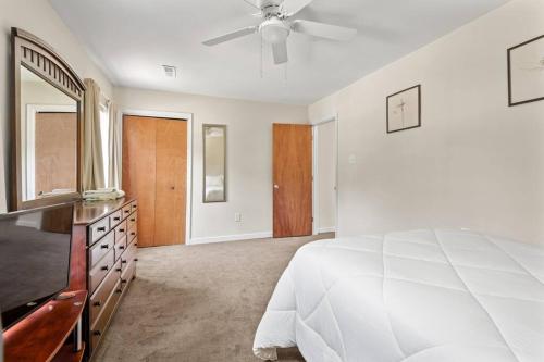 a white bedroom with a bed and a television at Prime Location 2 BR Oasis with Washer and Dryer in Spring Grove