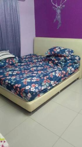 a small bed in a room with flowers on it at homestay RUSA in Kampong Kerayong