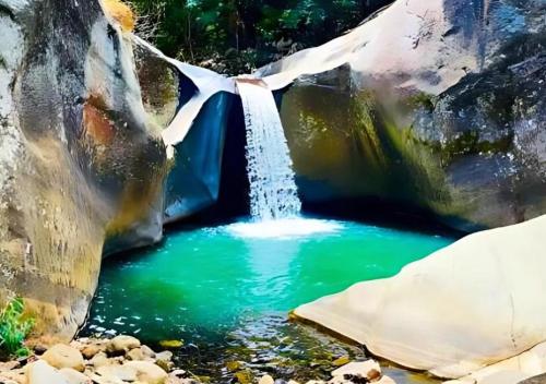 a waterfall in the middle of a pool of water at Bambara Ella Agro Resort & Camping in Haputale