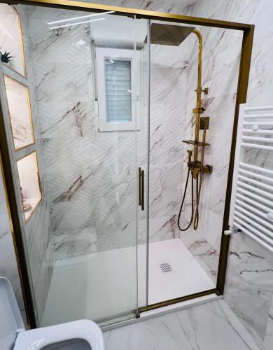 a shower with a glass door in a bathroom at Golden Apartment in Santander