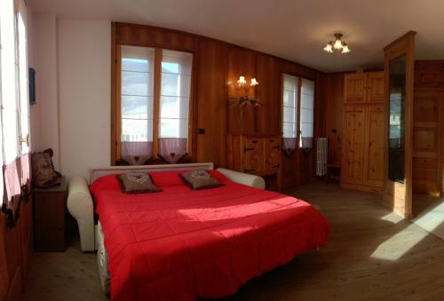 een slaapkamer met een bed met een rode deken bij Appartamento Federici in Bormio