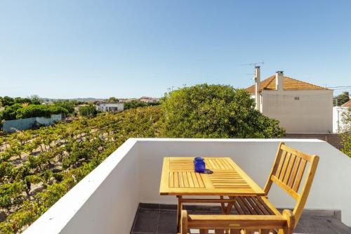 a wooden table and two chairs on a balcony at Pinheirinha Guest House in Alpiarça