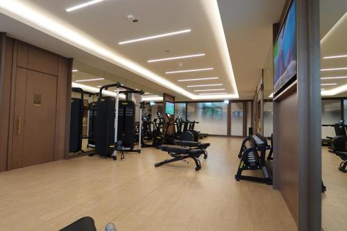 a gym with tread machines and a flat screen tv at Address Residence Bahrain in Rayyā