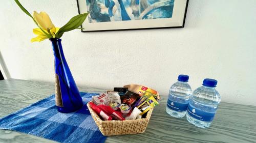 a basket of food next to a vase and water bottles at Welooveyou Top Fortuny in Costa Calma