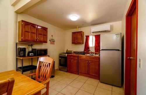 a kitchen with wooden cabinets and a stainless steel refrigerator at Beach Bungalow, Pool and direct Beach Access in San Felipe