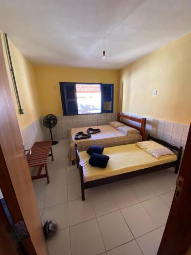 a room with two beds and a chair in it at Casa de praia DM in Luis Correia