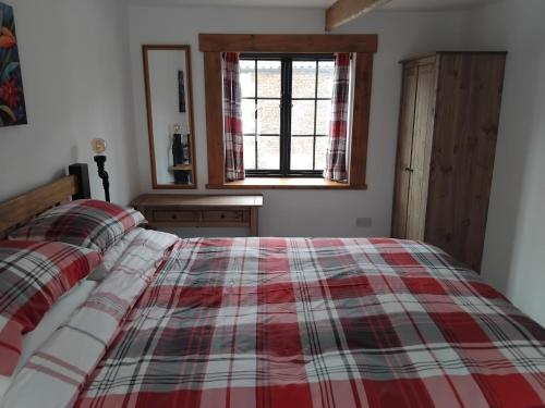 a bedroom with a red and white plaid bed at St Edmunds Brewery in Downham Market