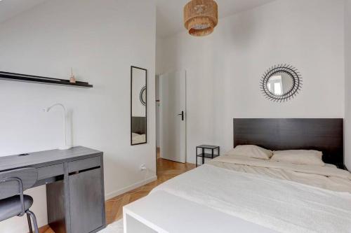 une chambre blanche avec un lit et un bureau dans l'établissement Le Duplex, à Versailles