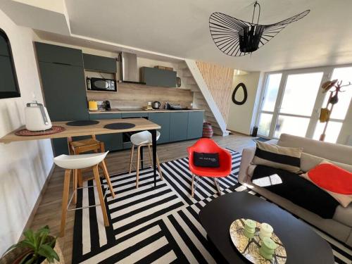 un salon avec un canapé et une cuisine dans l'établissement Les deux maisons - Little Green - Maison cosy proche pistes et lac, à Gérardmer