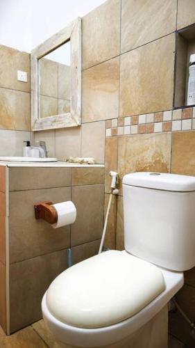 a bathroom with a white toilet and a sink at Manasha Watamu in Watamu