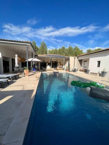 une piscine avec de l'eau bleue dans une cour dans l'établissement Joli havre de paix, à Prades-le-Lez