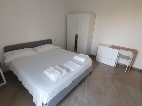 a bedroom with a white bed with towels on it at L'Acquaviva in Bisceglie