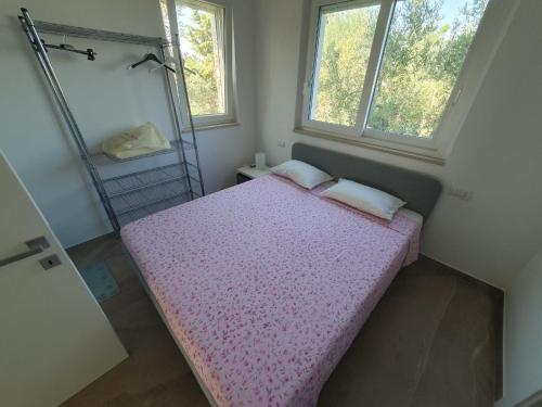 a small bedroom with two beds and two windows at L'Acquaviva in Bisceglie