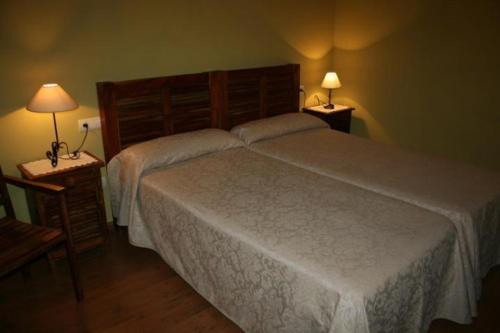 een slaapkamer met 2 bedden en 2 lampen op tafels bij Casa Don Benito in Arnego