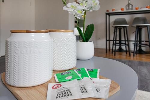 two white vases sitting on top of a table at Appartement 2 pièces 36m2, CDG Airport, Disneyland Paris, Asterix, Parc des expo, 10min gare de Chelles, Parking gratuit dans la ville in Le Pin