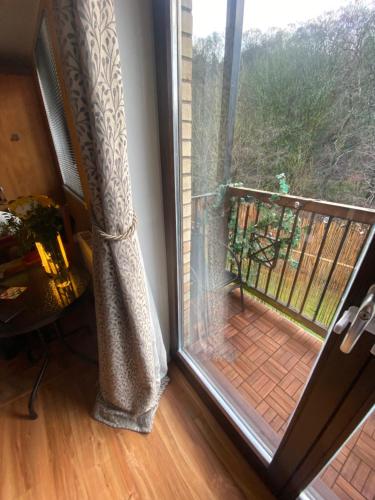 a sliding glass door with a view of a balcony at The Pentland Apartment in Penicuik