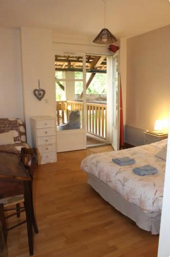 une chambre avec un lit et un balcon avec vue dans l'établissement Ferme ancienne des tilleuls, à Vinay
