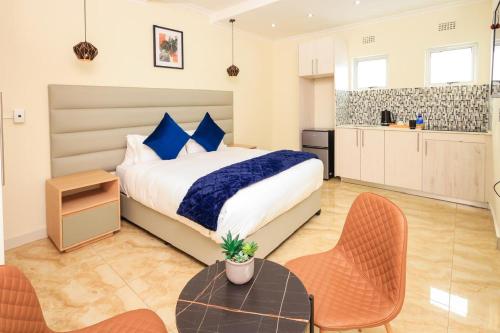 una camera con letto, tavolo e sedie di Clouds 52 Lodge a Johannesburg