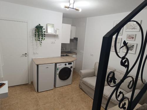 a laundry room with a washing machine and a couch at El Mirador in Chiclana de Segura