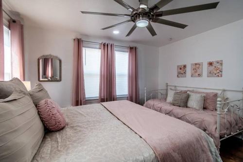 a bedroom with two beds and a ceiling fan at Tranquil Terrace - Whole Duplex in Corpus Christi