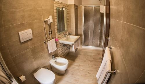 a bathroom with a toilet and a sink and a shower at Tourist Hotel in Potenza