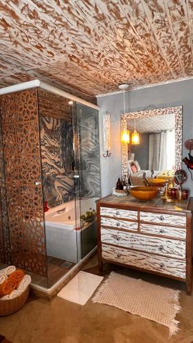 a bathroom with a shower and a sink and a tub at Villa Lulu Geribá in Búzios