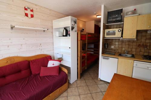un salon avec un canapé rouge dans une cuisine dans l'établissement Nouvelles Residences - Studio exposé Est avec balcon MAE-7824, à Tignes