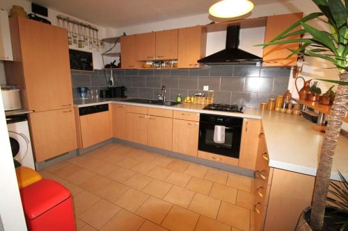 une cuisine avec des armoires en bois et un four à plaques de cuisson dans l'établissement Grand appartement avec sauna, à Strasbourg