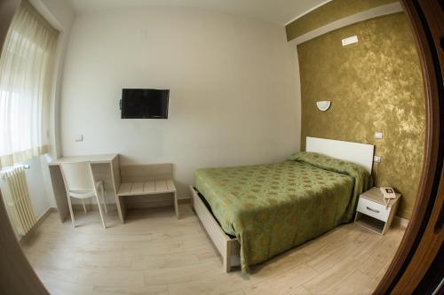 Tourist Hotel في بوتنزا: غرفة نوم بسرير وطاولة ومرآة