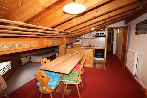 une cuisine avec une table et des chaises en bois dans l'établissement Résidence Rosset - Chaleureux 2 pièces proche des pistes MAE-2574, à Tignes