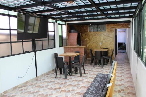 a patio with tables and chairs and a television at Hostel Mirador Aukán in Bogotá