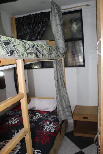 a bedroom with two bunk beds and a table at Hostel Mirador Aukán in Bogotá
