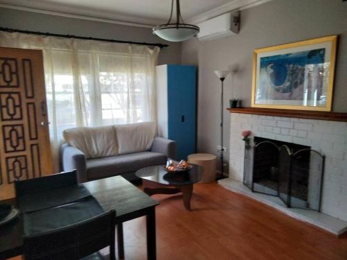 a living room with a couch and a fireplace at Cozy 2 bed villa in Narwee in Riverwood