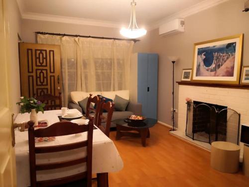 a living room with a table and a fireplace at Cozy 2 bed villa in Narwee in Riverwood