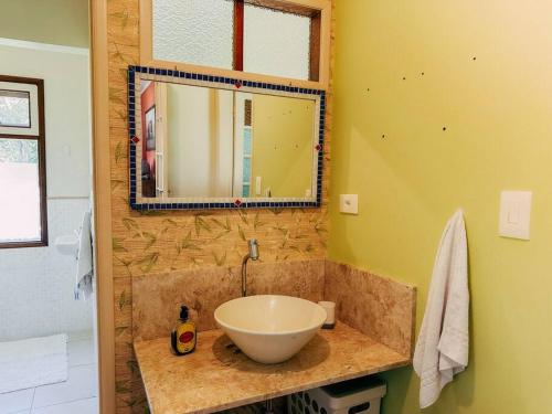 a bathroom with a bowl sink and a mirror at Refugio Jabuticaba, CASA DO TOPO - Romantismo sob o ceu estrelado in Santo Antônio do Pinhal