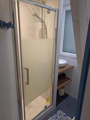 une douche avec une porte vitrée dans une salle de bain dans l'établissement Vivre à l'heurt, à Le Portel