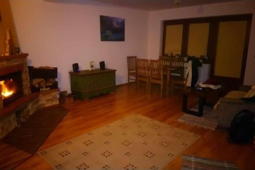 a living room with a fireplace and a table at Na Brzegu in Krempachy