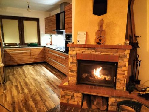 a living room with a brick fireplace in a kitchen at Na Brzegu in Krempachy
