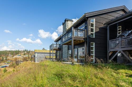 a black house on top of a hill at Nydelig utsikt, ski in out, 3 soverom in Aurdal