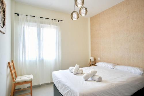 Un dormitorio con una cama con almohadas blancas. en Work & Pet friendly Urban Home next to the Beach, en Las Palmas de Gran Canaria