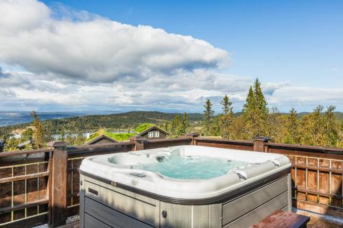 una vasca idromassaggio sul terrazzo di una casa di HYTTEEVENTYR I VALDRES MED JACUZZI, 5 soverom, alpinbakke og skiløyper like ved! ad Aurdal