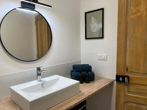 une salle de bain avec un lavabo blanc et un miroir dans l'établissement MahéRius N 1, à Gerbéviller